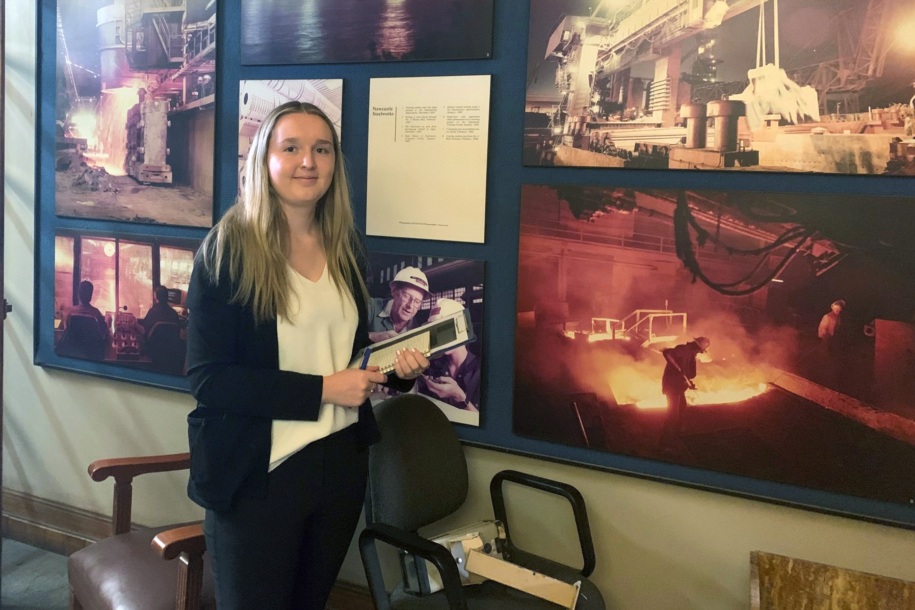 AbbyWilkinson Woman standing in front of images of buildings.