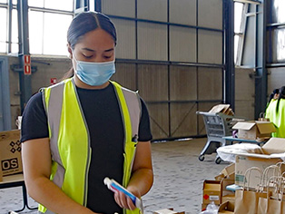 A warehouse worker is sorting hand sanitiser into bags for delivery to school students across NSW. A warehouse worker is sorting hand sanitiser into bags for delivery to school students across NSW.